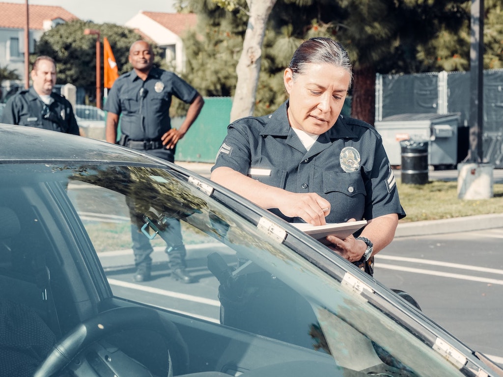 Policía revisando documentación de conductor de automóvil 