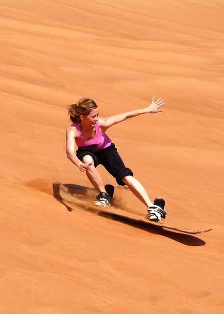 Una mujer practicando el sandboarding. 